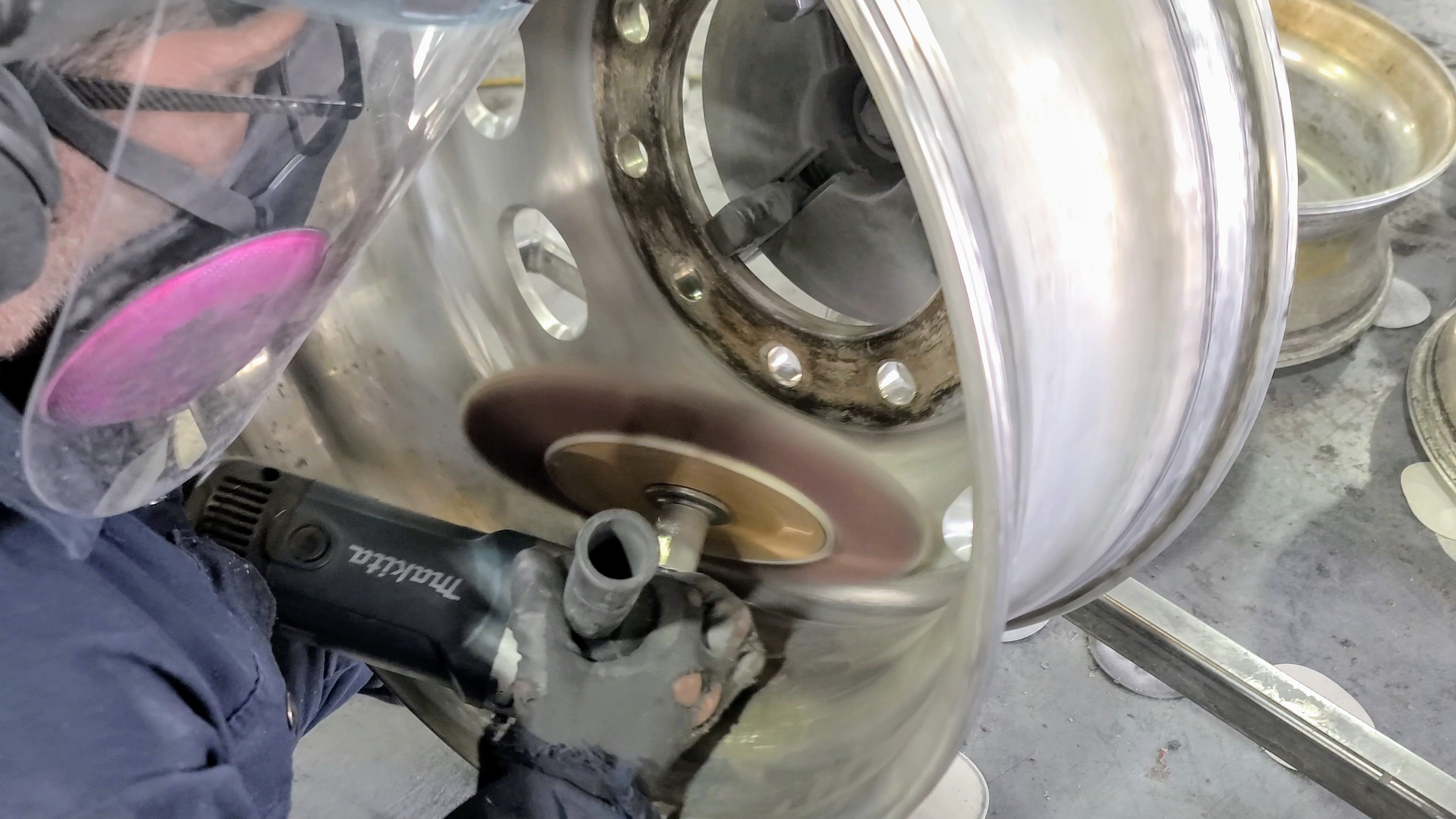 Dry sanding pits from the water channel of an aluminum drive semi-truck rim.